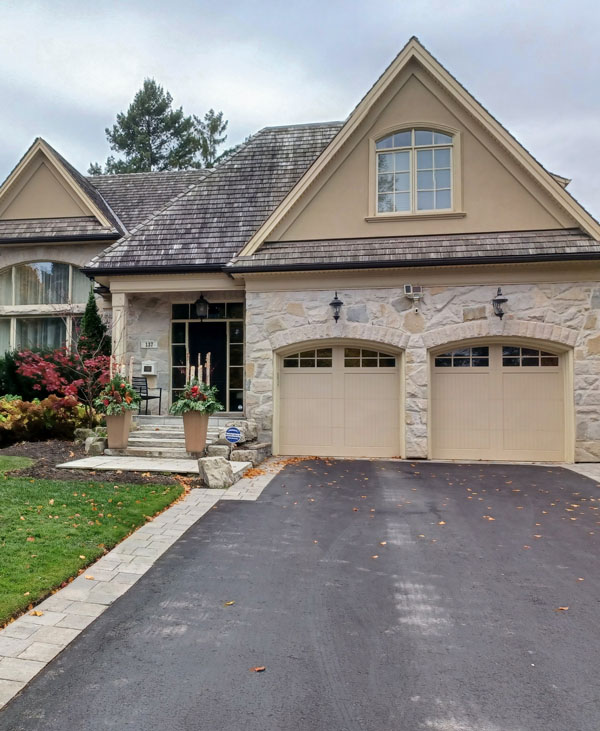 Classic double garage doors installed on a residential stone house