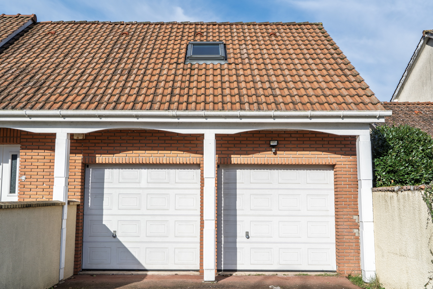 White garage doors matching brick exterior
